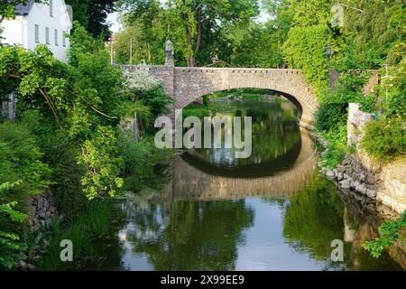 Blick auf eine alte Steinbrücke über einen Kanal in der Stadt Stockfoto