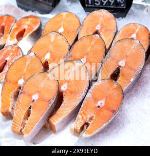 Steaks mit frischem Lachsfisch auf der Theke. Geschnittener roher Fisch zum Verkauf. Fisch- und Meeresfrüchtegeschäft Stockfoto