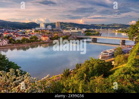 Linz, Österreich. Luftbild des Flusses Linz, Österreich während des Frühlingsuntergangs mit Reflexion der Stadt in der Donau. Stockfoto