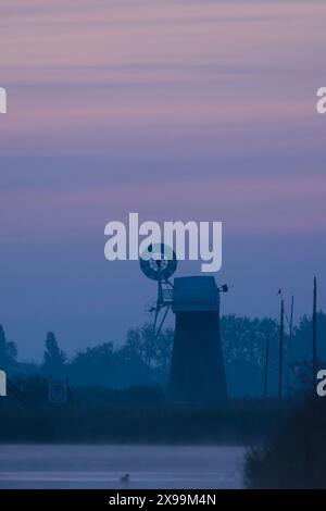 St Benet's Ebene Entwässerungsmühle, blauer Nebel in der Abenddämmerung, vom Fluss Bure aus gesehen, Stockfoto