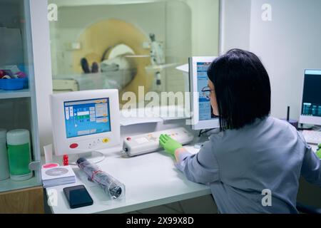 Frau Ärztin, die eine MRT-Untersuchung am Patienten durchführt Stockfoto