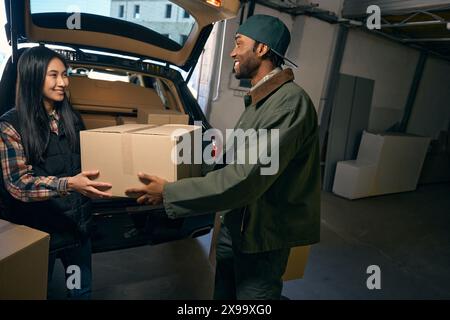 Ein Paar nimmt Sachen aus einem Auto in einem Lagerservice Stockfoto