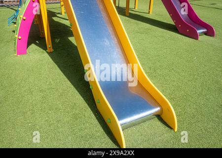 Detail einer Metall- und Plastikrutsche auf einem Kinderspielplatz Stockfoto