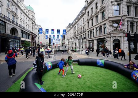 Kinder spielen Fußball in der Regent Street am ersten Tag des UEFA Champions League Festivals in London. Das Champions-League-Finale zwischen Borussia Dortmund und Real Madrid findet am Samstag, den 1. Juni in Wembley statt. Bilddatum: Donnerstag, 30. Mai 2024. Stockfoto