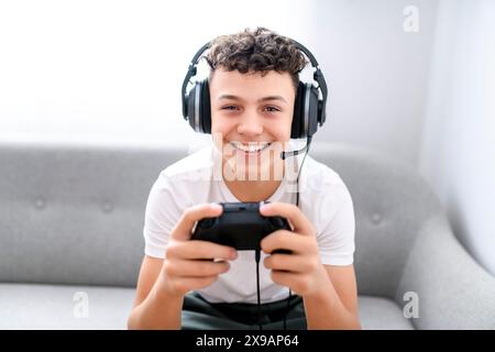 Porträt eines Teenagers, der im Urlaub Videospiele im fernsehen spielt, sitzt zu Hause auf der gemütlichen Couch Stockfoto
