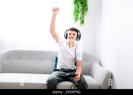 Porträt eines Teenagers, der im Urlaub Videospiele im fernsehen spielt, sitzt zu Hause auf der gemütlichen Couch Stockfoto