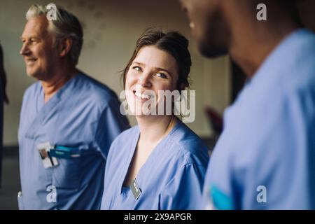 Lächelnde Ärztin mit multirassischen Kollegen im Krankenhaus Stockfoto