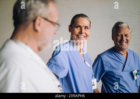 Glückliche männliche und weibliche Seniorärzte reden im Krankenhaus Stockfoto