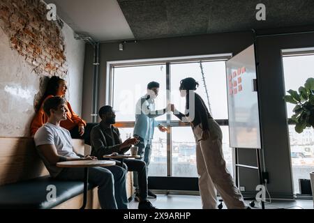 Geschäftskollegen geben High-Five-Mitarbeiter in Meetings im Büro Stockfoto