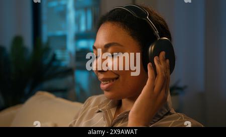 Afroamerikanerin lächelnde Geschäftsfrau arbeitet Computergeschäft von zu Hause aus weibliche Freiberuflerin Genießen Sie den Klang in kabellosen Kopfhörern Musik-App hören Stockfoto