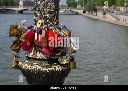 Paris, Frankreich 05.25.2024 Liebesschlösser, die an einem Laternenpfosten auf einer Brücke über die seine befestigt sind. Stockfoto