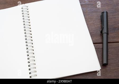 Weißes Papier leeres Buchmockup mit Stift auf Holztisch Stockfoto