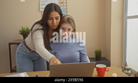 Zwei Frauen arbeiten an einem Projekt mit einem Laptop in einem modernen Home Office-Umfeld zusammen. Stockfoto