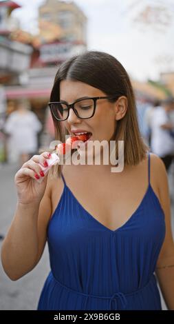 Die atemberaubende hispanische Frau serviert leckere japanische Erdbeerbonbons in der nakamise Street, einem berühmten Ort in tokio Stockfoto