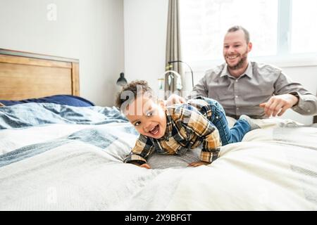 Vater und Sohn kuscheln zusammen im Schlafzimmer Stockfoto