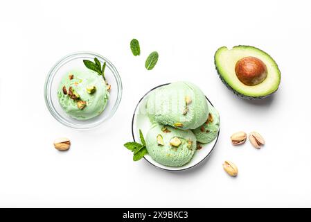 Grüne Avocado Pistazien Kokos Eislöffel in Schüssel isoliert auf weißem Hintergrund. Trendiges hausgemachtes veganes Eis mit grünen Minzblättern und Avoc Stockfoto