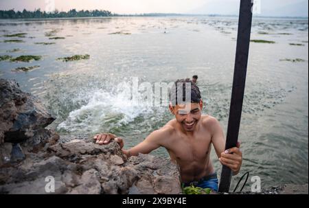 30. Mai 2024, Srinagar, Jammu & Kashmir, Indien: Einheimische kühlen sich bei einem Bad im Dal Lake an einem heißen Sommerabend ab. Eine Rekordhitzewelle hat die indische Hauptstadt Delhi und Gebiete im Nordwesten und in den zentralen Regionen des Landes überschwemmt, wobei die Temperaturen während der ganzen Woche nahezu auf Allzeithochwerten lagen. (Credit Image: © Idrees Abbas/SOPA Images via ZUMA Press Wire) NUR REDAKTIONELLE VERWENDUNG! Nicht für kommerzielle ZWECKE! Stockfoto