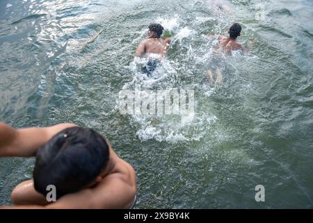 30. Mai 2024, Srinagar, Jammu & Kashmir, Indien: Einheimische kühlen sich bei einem Bad im Dal Lake an einem heißen Sommerabend ab. Eine Rekordhitzewelle hat die indische Hauptstadt Delhi und Gebiete im Nordwesten und in den zentralen Regionen des Landes überschwemmt, wobei die Temperaturen während der ganzen Woche nahezu auf Allzeithochwerten lagen. (Credit Image: © Idrees Abbas/SOPA Images via ZUMA Press Wire) NUR REDAKTIONELLE VERWENDUNG! Nicht für kommerzielle ZWECKE! Stockfoto