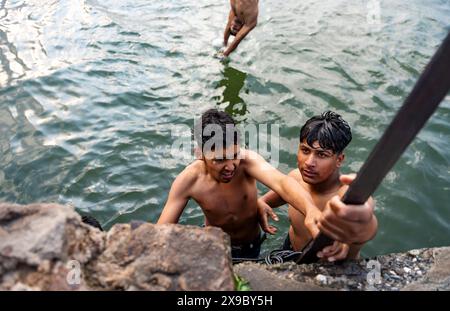 30. Mai 2024, Srinagar, Jammu & Kashmir, Indien: Einheimische kühlen sich bei einem Bad im Dal Lake an einem heißen Sommerabend ab. Eine Rekordhitzewelle hat die indische Hauptstadt Delhi und Gebiete im Nordwesten und in den zentralen Regionen des Landes überschwemmt, wobei die Temperaturen während der ganzen Woche nahezu auf Allzeithochwerten lagen. (Credit Image: © Idrees Abbas/SOPA Images via ZUMA Press Wire) NUR REDAKTIONELLE VERWENDUNG! Nicht für kommerzielle ZWECKE! Stockfoto