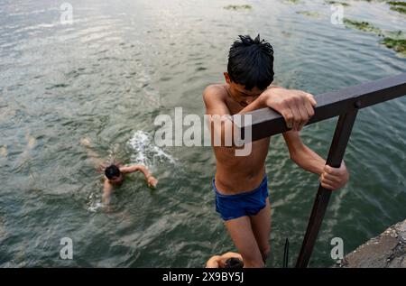 30. Mai 2024, Srinagar, Jammu & Kashmir, Indien: Einheimische kühlen sich bei einem Bad im Dal Lake an einem heißen Sommerabend ab. Eine Rekordhitzewelle hat die indische Hauptstadt Delhi und Gebiete im Nordwesten und in den zentralen Regionen des Landes überschwemmt, wobei die Temperaturen während der ganzen Woche nahezu auf Allzeithochwerten lagen. (Credit Image: © Idrees Abbas/SOPA Images via ZUMA Press Wire) NUR REDAKTIONELLE VERWENDUNG! Nicht für kommerzielle ZWECKE! Stockfoto