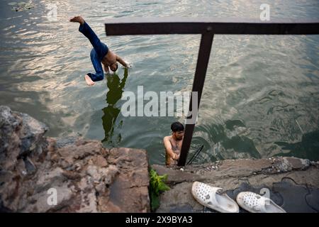 30. Mai 2024, Srinagar, Jammu & Kashmir, Indien: Einheimische kühlen sich bei einem Bad im Dal Lake an einem heißen Sommerabend ab. Eine Rekordhitzewelle hat die indische Hauptstadt Delhi und Gebiete im Nordwesten und in den zentralen Regionen des Landes überschwemmt, wobei die Temperaturen während der ganzen Woche nahezu auf Allzeithochwerten lagen. (Credit Image: © Idrees Abbas/SOPA Images via ZUMA Press Wire) NUR REDAKTIONELLE VERWENDUNG! Nicht für kommerzielle ZWECKE! Stockfoto