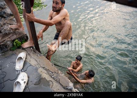 30. Mai 2024, Srinagar, Jammu & Kashmir, Indien: Einheimische kühlen sich bei einem Bad im Dal Lake an einem heißen Sommerabend ab. Eine Rekordhitzewelle hat die indische Hauptstadt Delhi und Gebiete im Nordwesten und in den zentralen Regionen des Landes überschwemmt, wobei die Temperaturen während der ganzen Woche nahezu auf Allzeithochwerten lagen. (Credit Image: © Idrees Abbas/SOPA Images via ZUMA Press Wire) NUR REDAKTIONELLE VERWENDUNG! Nicht für kommerzielle ZWECKE! Stockfoto