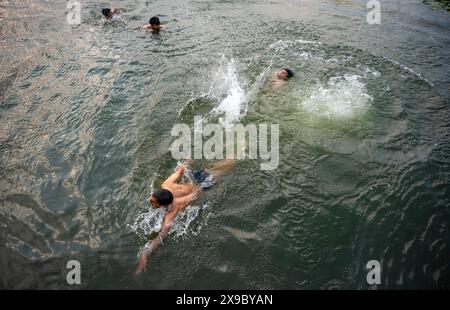 30. Mai 2024, Srinagar, Jammu & Kashmir, Indien: Einheimische kühlen sich bei einem Bad im Dal Lake an einem heißen Sommerabend ab. Eine Rekordhitzewelle hat die indische Hauptstadt Delhi und Gebiete im Nordwesten und in den zentralen Regionen des Landes überschwemmt, wobei die Temperaturen während der ganzen Woche nahezu auf Allzeithochwerten lagen. (Credit Image: © Idrees Abbas/SOPA Images via ZUMA Press Wire) NUR REDAKTIONELLE VERWENDUNG! Nicht für kommerzielle ZWECKE! Stockfoto