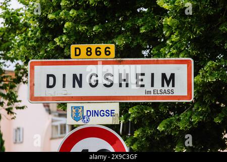 PRODUKTION - 29. Mai 2024, Frankreich, Dingsheim: Das Stadtzeichen von Dingsheim befindet sich am Ortseingang und trägt auch einen Aufkleber mit der Aufschrift „im ELSASS“. Die Sonderregelungen des lokalen Rechts im Elsass und Lothringen besagen, dass in den Regionen, die nach dem Ersten Weltkrieg wieder Teil Frankreichs wurden, deutsche Regelungen in einer Reihe von Bereichen des gesellschaftlichen Lebens beibehalten wurden. Das reicht vom Jagdrecht über religiöse Praxis und Krankenversicherung bis hin zu Kataster und Verbänden. Die Grenzregion hat derzeit Schwierigkeiten sicherzustellen, dass das lokale Recht im Laufe der nicht untergraben wird Stockfoto