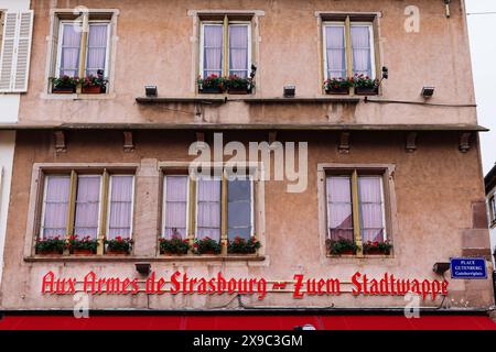 PRODUKTION - 29. Mai 2024, Frankreich, Straßburg: Die Fassade des elsässischen Restaurants 'Aux Armes de Strasbourg - Zuem Stadtwappen' ist im Stadtzentrum von Straßburg auf dem 'Place Gutenberg' oder 'Guteberriplatz' zu sehen. In den Sonderregelungen des lokalen Rechts im Elsass und Lothringen heißt es, dass in den Regionen, die nach dem Ersten Weltkrieg wieder Teil Frankreichs wurden, deutsche Vorschriften in vielen Bereichen des gesellschaftlichen Lebens eingehalten wurden. Das reicht von Jagdrechten, religiöser Praxis und Krankenversicherung bis hin zu Grundbuchvereinigungen und Verbänden. Die Grenzregion hat derzeit Schwierigkeiten damit Stockfoto