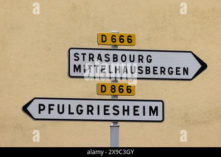 PRODUKTION - 29. Mai 2024, Frankreich, Griesheim Sur Souffel: Zwei Straßenschilder weisen auf den Weg nach Straßburg, Mittelhausbergn und Pfulgriesheim. Die Sonderregelungen des lokalen Rechts im Elsass und Lothringen besagen, dass in den Regionen, die nach dem Ersten Weltkrieg wieder Teil Frankreichs wurden, deutsche Vorschriften in vielen Bereichen des gesellschaftlichen Lebens beibehalten wurden. Das reicht vom Jagdrecht über religiöse Praxis und Krankenversicherung bis hin zu Kataster und Verbänden. Die Grenzregion hat derzeit Schwierigkeiten sicherzustellen, dass das lokale Recht im Zuge der Normung der Vorschriften nicht untergraben wird. Foto: Philipp von Stockfoto