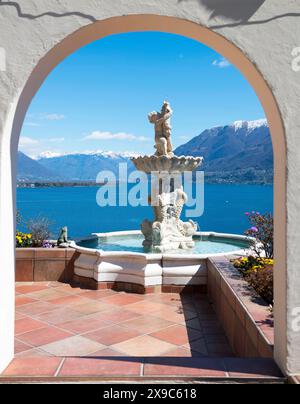 Terrasse mit einer Statue mit Panoramablick über den Lago Maggiore und den schneebedeckten Berg an einem sonnigen Tag in Ronco sopra Ascona, Tessin, Schweiz Stockfoto