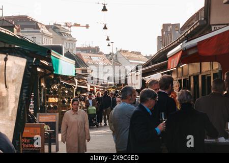 An einem sonnigen Herbstnachmittag schlendern die Käufer durch verschiedene Stände im Naschmarkt, einem Open-Air-Markt in Wien, Österreich Stockfoto