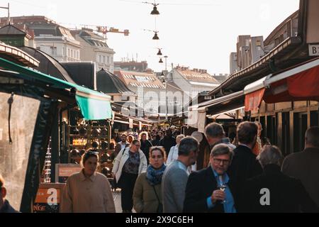 An einem sonnigen Herbstnachmittag schlendern die Käufer durch verschiedene Stände im Naschmarkt, einem Open-Air-Markt in Wien, Österreich Stockfoto