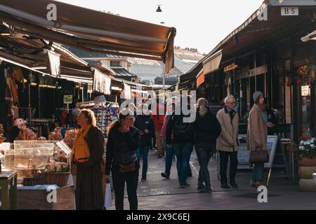 An einem sonnigen Herbstnachmittag schlendern die Käufer durch verschiedene Stände im Naschmarkt, einem Open-Air-Markt in Wien, Österreich Stockfoto