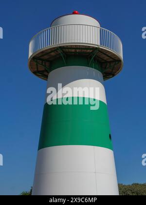 Leuchtturm in Grün und weiß vor hellblauem Himmel, Dünen und Strandhütten am Strand von Ostend an der Nordsee, oostende, belgien Stockfoto