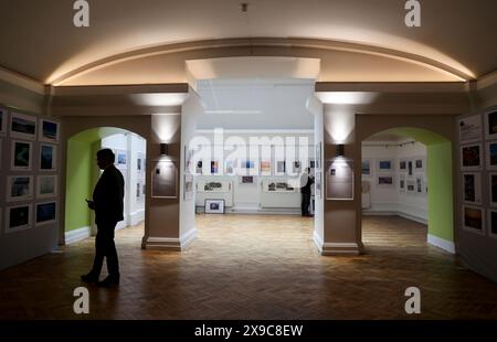 London, Großbritannien. 30. Mai 2024. Die Menschen sehen sich Fotos auf einer UK-China-Kunstveranstaltung in London, Großbritannien, am 30. Mai 2024 an. Eine Kunstveranstaltung, bei der die Kulturen entlang des Gelben Flusses und der Themse, zwei bekannte Flüsse in China und Großbritannien (Großbritannien), thematisiert wurden, begann am Freitag im Zentrum von London. Die Veranstaltung, die gemeinsam von der UK-China Photography Association und der UK-China Film Collab organisiert wird, trägt den Titel „Beautiful China, Beautiful Britain: Common People entlang des Gelben Flusses“. Quelle: Han Yan/Xinhua/Alamy Live News Stockfoto