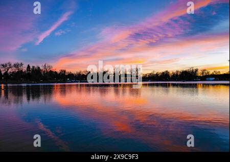 Ein wunderschöner Sonnenuntergang über Smith Lake im Historic Washington Park in Denver, Colorado, mit den bunten Wolken, die sich im Wasser spiegeln. Stockfoto