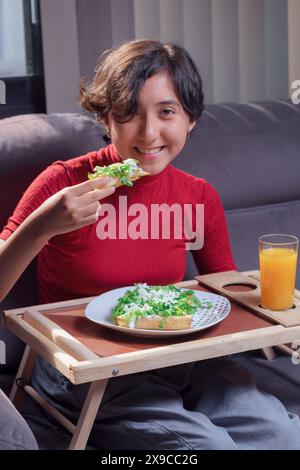 Mexikanische Taquitos, Hühnchen, Käse und Salat, junges Mädchen isst traditionelle frittierte Tacos und sie lächelt in die Kamera. Stockfoto