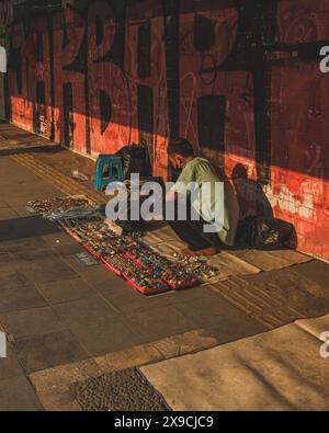 Jakarta, Indonesien - 7. Mai 2024. Der Verkäufer hockt in der Nähe der Wand des langen Flurs. Stockfoto