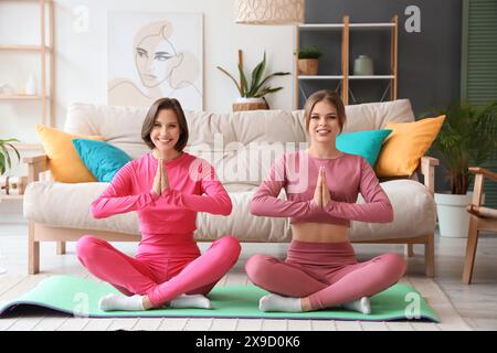 Weibliche Freunde, die zu Hause meditieren Stockfoto