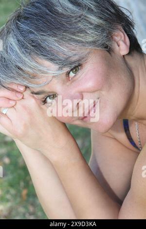 Porträt einer Frau mittleren Alters, die sich im Freien erholt Stockfoto