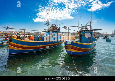 Traditionelle bunte Boote mit Augen Maltese Luzzu im türkisblauen Wasser im Hafen des mediterranen Fischerdorfes Marsaxlokk, Kulturerbe Stockfoto