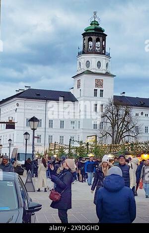 Salzburg, Österreich - 23. Dezember 2023: Weihnachtsdekoration und der Uhrturm der Neuen Residenz auf dem Salzburger Weihnachtsmarkt am Residenzplatz Stockfoto