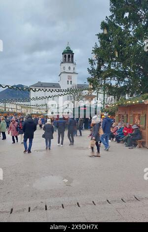 Salzburg, Österreich - 23. Dezember 2023: Weihnachtsdekoration und der Uhrturm der Neuen Residenz auf dem Salzburger Weihnachtsmarkt am Residenzplatz Stockfoto