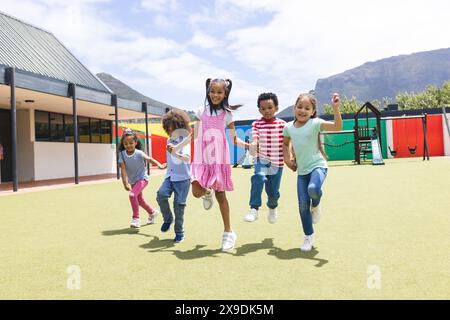 In der Schule läuft eine Gruppe junger Schüler draußen Stockfoto