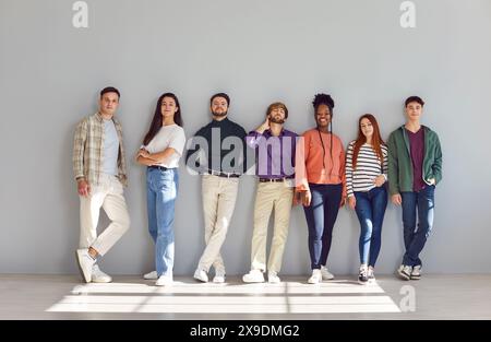 Sieben selbstbewusste Menschen unterschiedlicher Ethnien stehen mit entspannter Haltung nach vorne. Stockfoto