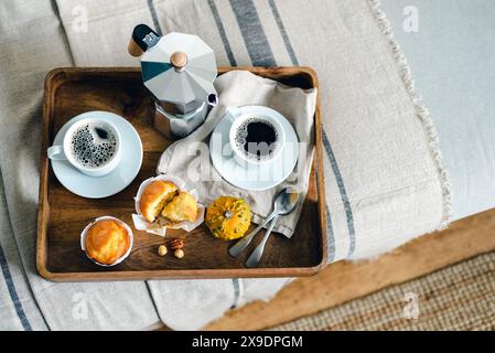 Morgenkaffee mit Kürbismuffins auf einem Holztablett. Stockfoto