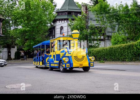 Sinaia, Rumänien - 3. Juli 2021: Farbenfroher Zug für Kinder in einer Straße im Zentrum der Stadt in der Nähe des Bucegi-Gebirges (Muntii Bucegi) in Prahova Stockfoto