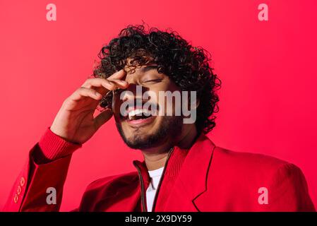 Junger Indianer in roter Jacke, der ein Telefongespräch führt. Stockfoto