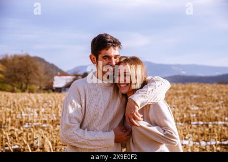 Glückliches Paar, das auf einem ernteten Feld lacht Stockfoto